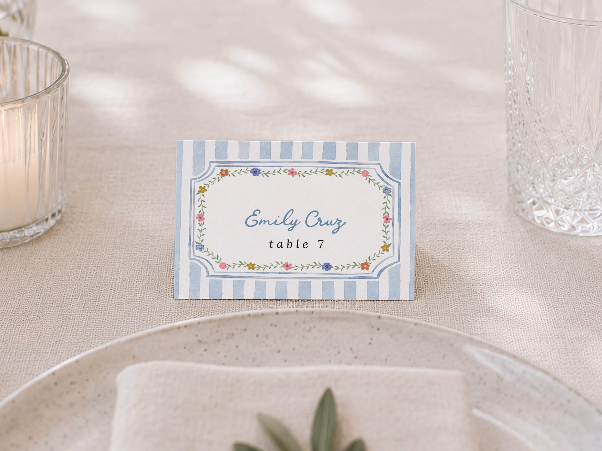 Blue striped Emily Cruz place card standing on a table